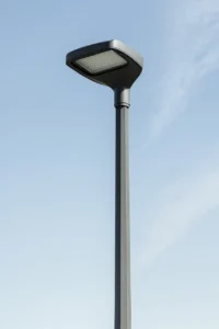 پایه چراغ لوله‌ای یا چندوجهی؟ مقایسه بصری: پایه چراغ LED چندوجهی مدرن در برابر آسمان آبی روشن.